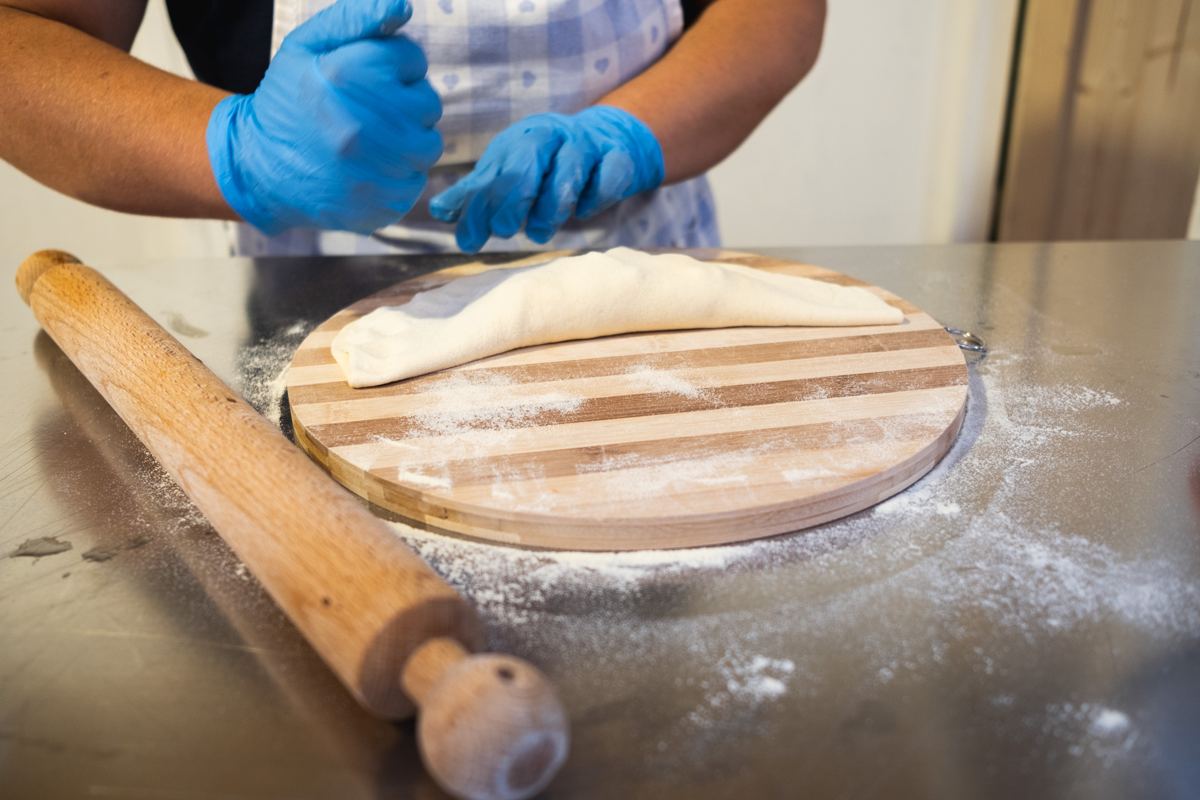 Mani che lavorano l'impasto sul tagliere